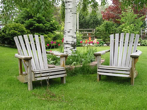 Eleganckie krzesła ogrodowe wykonane z drewna stanowią idealną element ozdobny naszego ogródka.